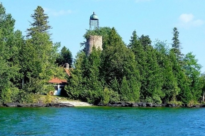 a small boat in a body of water surrounded by trees