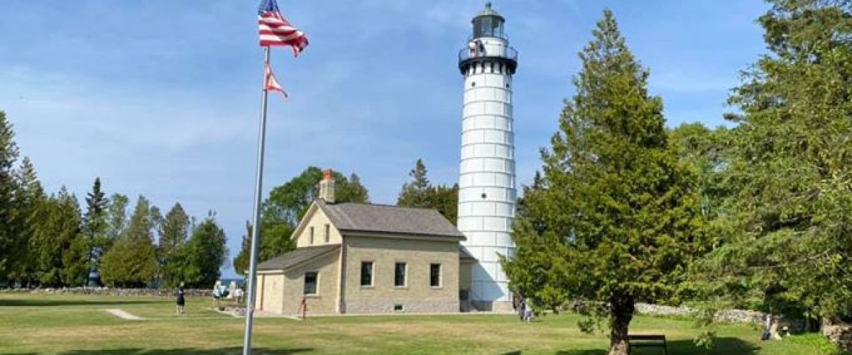 a small clock tower in the middle of a field