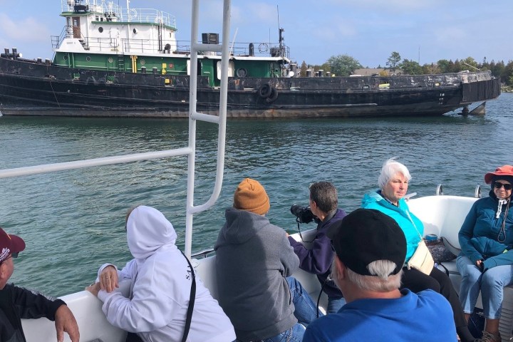 a group of people in a tour boat in baileys harbor viewing a shipwreck