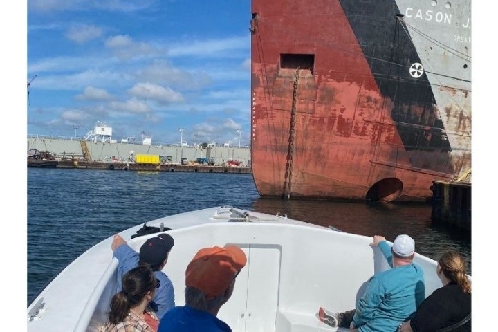 a group of people sitting in front of a body of water
