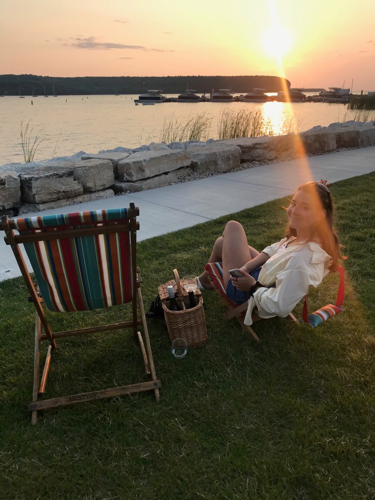 a person sitting on a beach chair next to a body of water