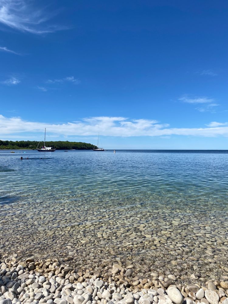 a sandy beach next to a body of water