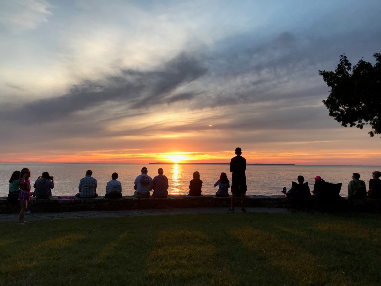 a group of people on a beach watching the sunset