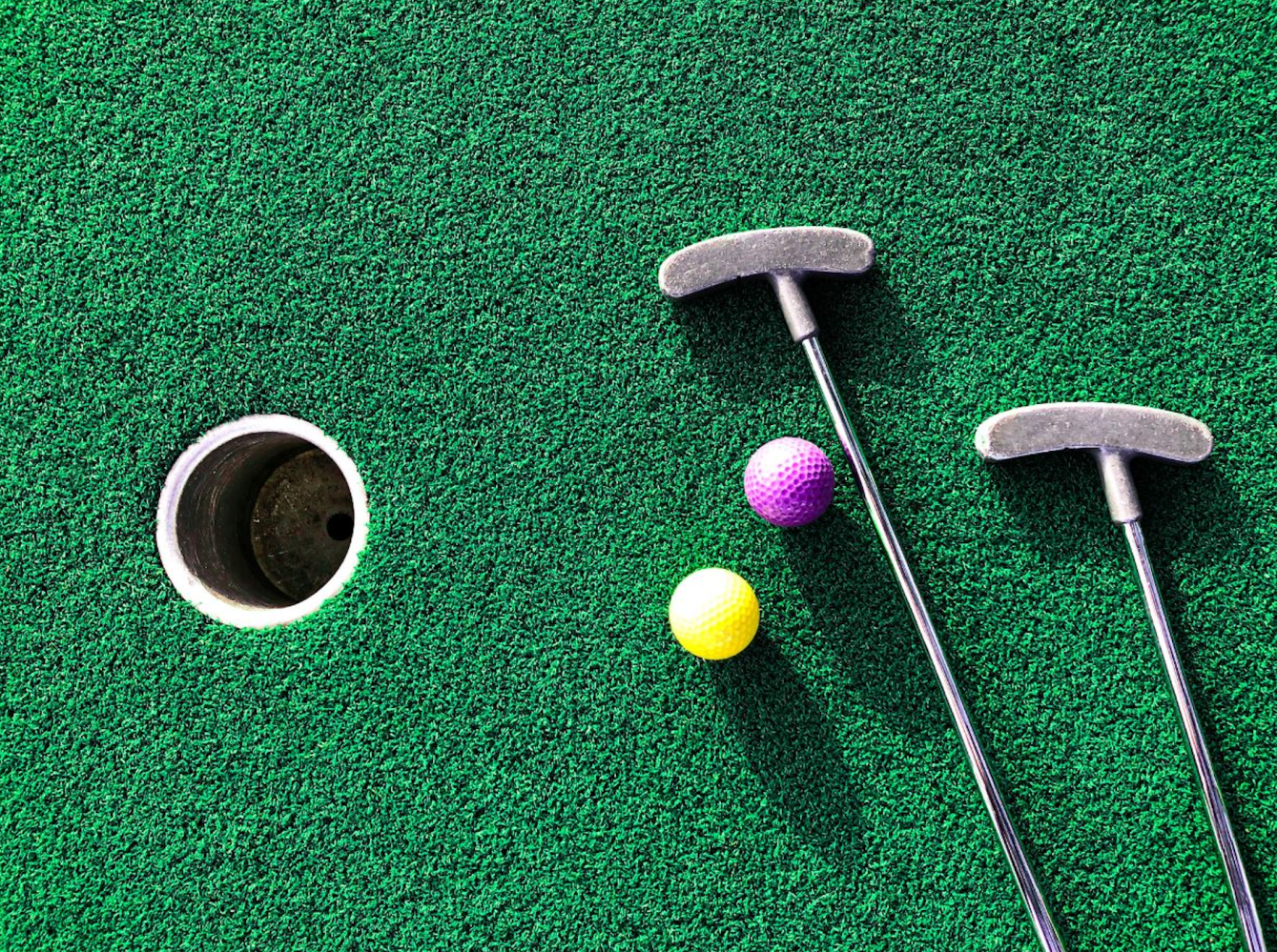 mini golf putters and balls on putting green