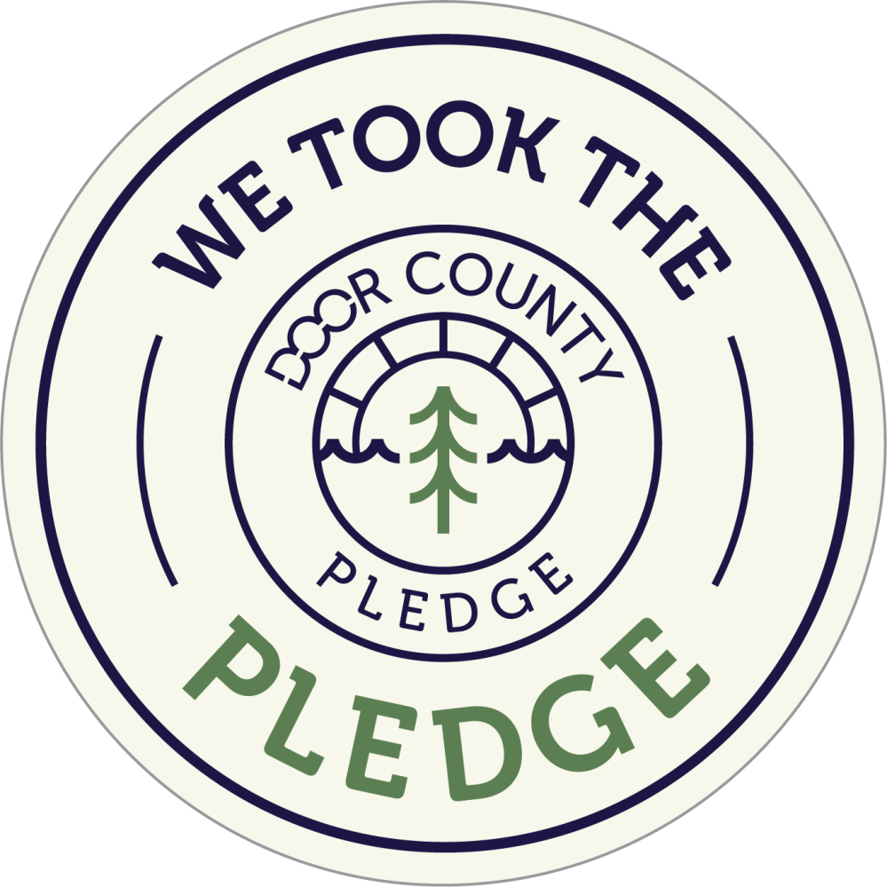 Circular badge with 'We Took the Door County Pledge' and tree and waves icon.