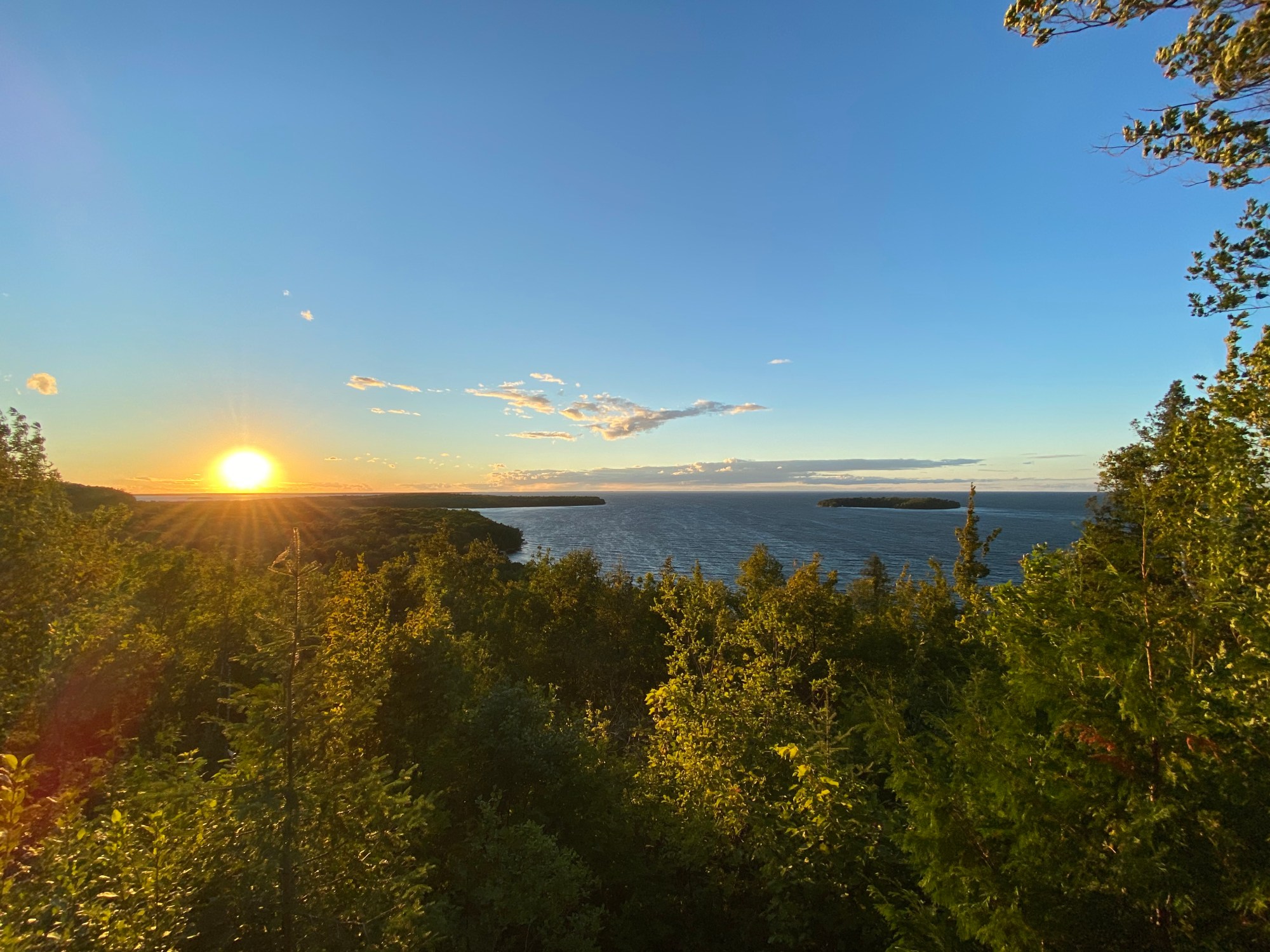peninsula state park Sunset over a lake with trees in the foreground and clear sky.